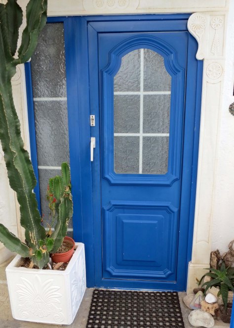 This blue Mykonos door is decorated by a cactus.