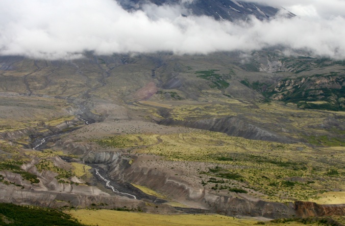 Looking down at the valley floor in front of Mt. St. Helen, the Toutle River carves through debris left behind by the eruption which reaches a depth of over 300 feet in places.