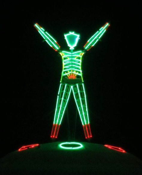 The Man at Burning Man raises his arms just prior to the burn.