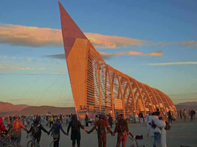 The Burning Man Temple at sunrise is guaranteed to draw a crowd. Burners had spontaneously joined hands as the sun little up the Temple.